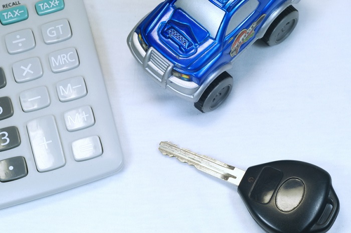 Calculator, toy car, and key representing Nissan financing