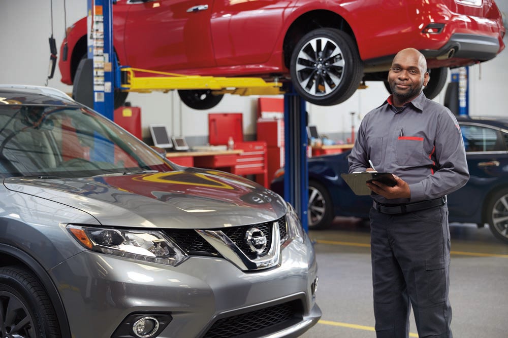 Certified technician performing routine maintenance on a Nissan
